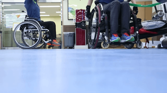 실내에서 휠체어를 탄 사람들이 운동하는 모습