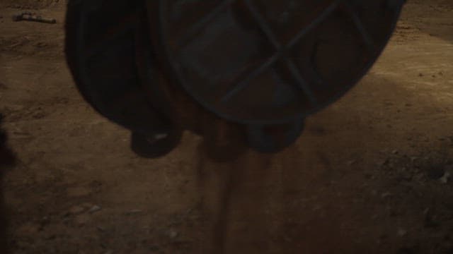 Worker handling manhole covers in a factory