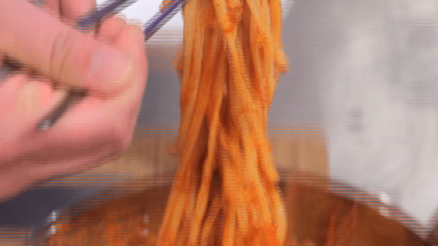 오징어 볶음 국수를 젓가락으로 들어올리는 모습