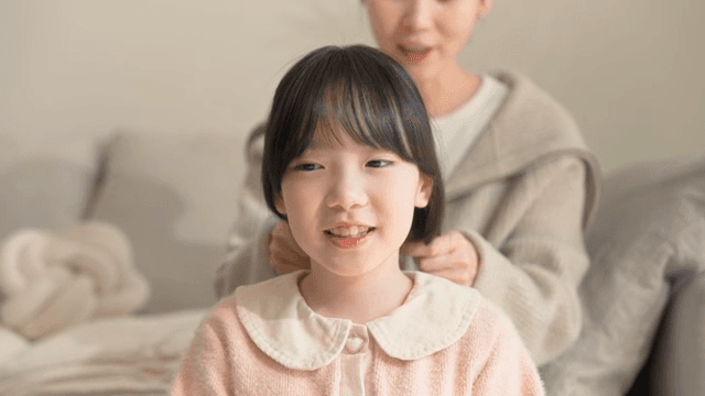 Child smiling while getting her hair done