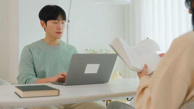 Couple talking at living room table in bright interior