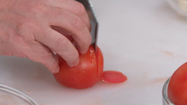 Slicing a Fresh Tomato on a White Cutting Board