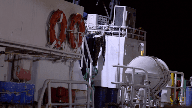 Ship deck with lifebuoys at night