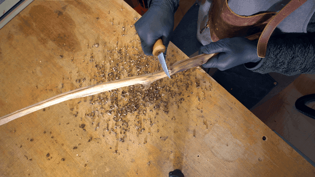 나무 막대를 조각하는 사람