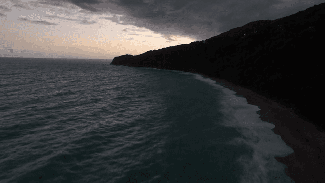 파도가 있는 해질녘의 고요한 해변