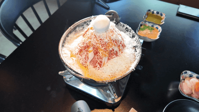 Cheese covering and melting over mala hot pot
