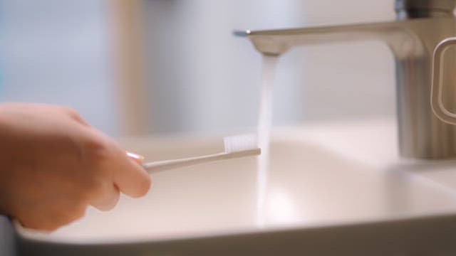 세면대에서 치약으로 칫솔을 준비하는 모습