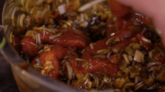 양념된 고기와 채소를 섞는 장면