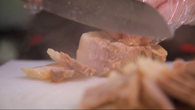 도마 위에서 삶은 돼지고기 썰기