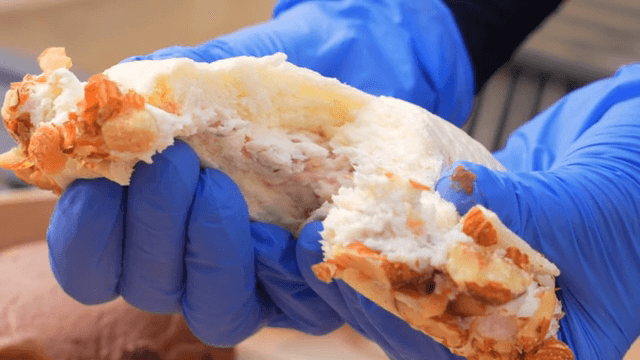 크림이 든 페이스트리를 잡고 있는 장갑 낀 손