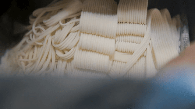 Noodles pulled out of a machine