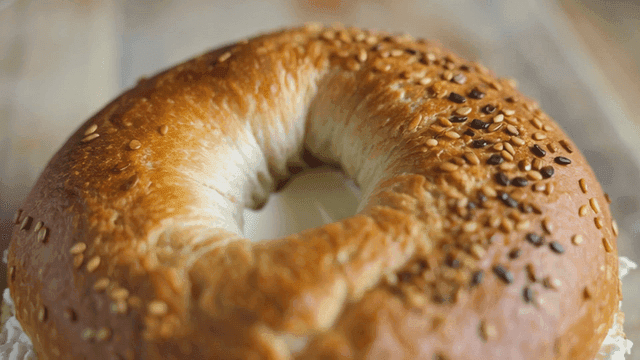 Cream cheese bagel on wooden cutting board