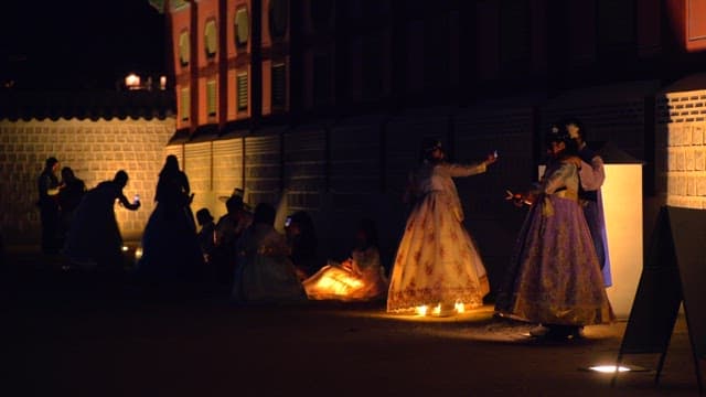 한복을 입고 사진을 찍으며 경복궁을 즐기는 사람들