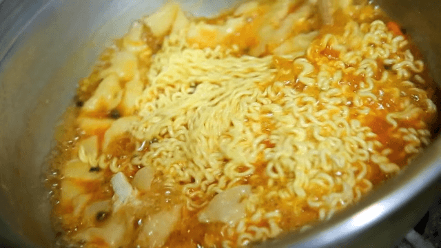 Stirring boiling hand-pulled dough ramyeon with chopsticks