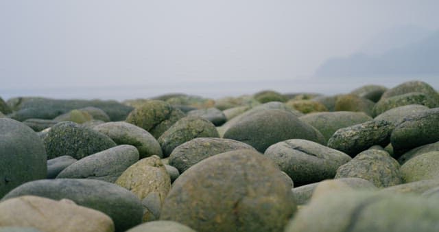 자갈 해변 위를 조심스럽게 걷는 사람