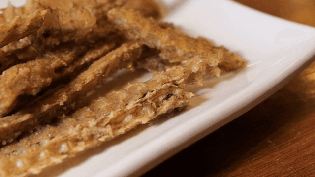 Crispy fried eel bones on a white plate