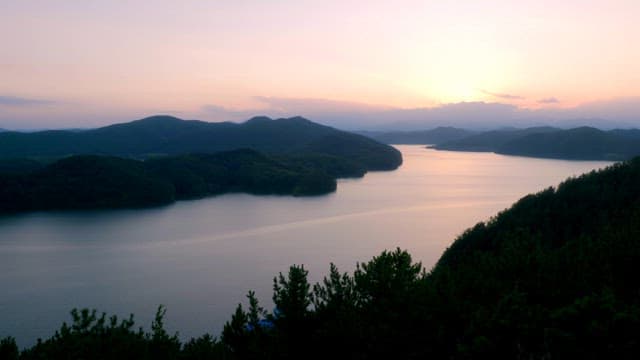 Serene lake surrounded by mountains at sunset