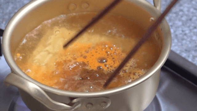 Cooking ramyeon in a pot with chopsticks