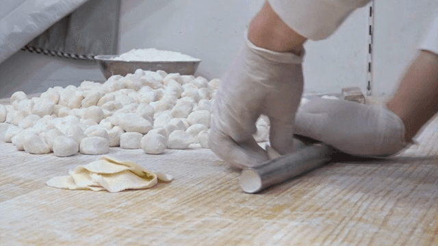 Rolling dough in a kitchen with flour