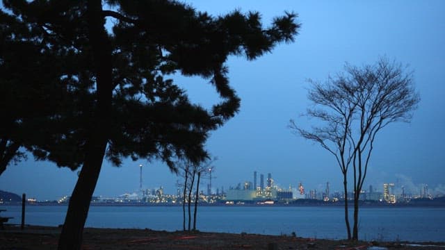 산업 도시가 보이는 황혼의 바닷가