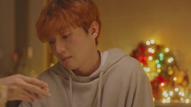 크리스마스 조명이 장식된 방안에서 우울해하는 남자