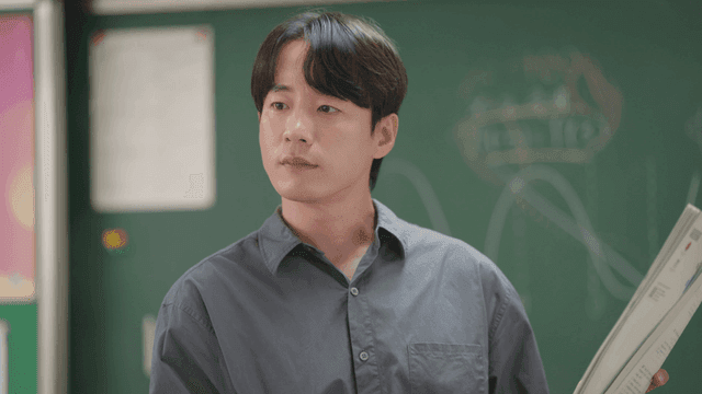 수업 중 교과서를 설명하는 교사