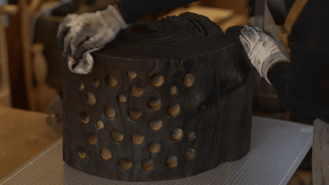 검게 탄 나무 조각을 행주 수건으로 닦는 장인