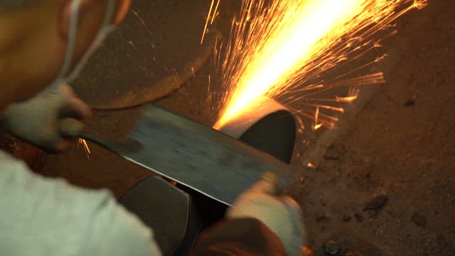 Worker sharpening a knife in a workshop