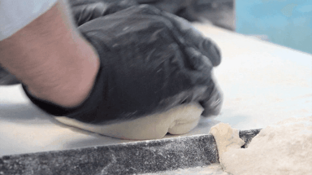 밀가루를 뿌린 조리대에서 치대지는 반죽