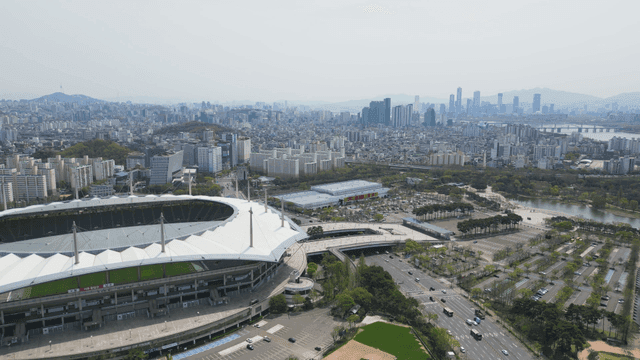 A large stadium in a bustling cityscape