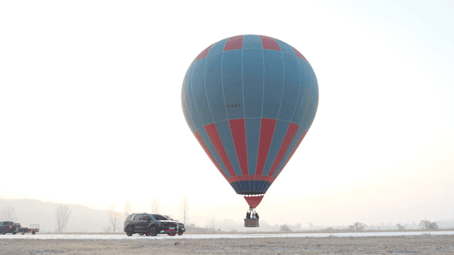Hot air balloon in a misty field at sunrise