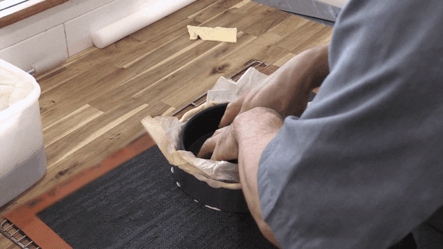 조리대 위에서 베이킹 틀에 반죽을 준비하는 제빵사