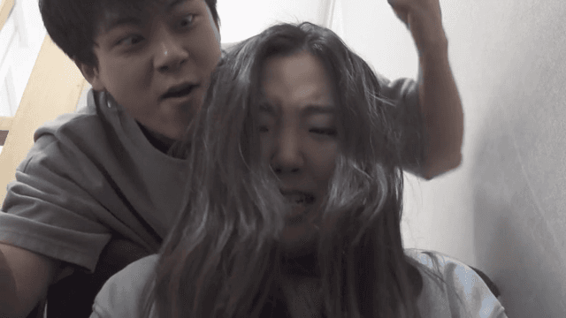 힘겨워하는 여성 뒤로 장난치는 남성