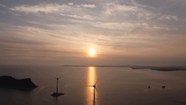Sunset over the sea with wind turbines