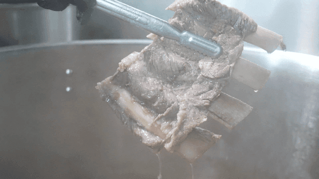Tongs for scooping beef rib soup meat out of large pot