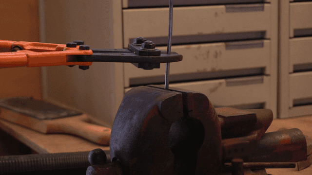 볼트 커터로 금속 와이어 자르는 모습