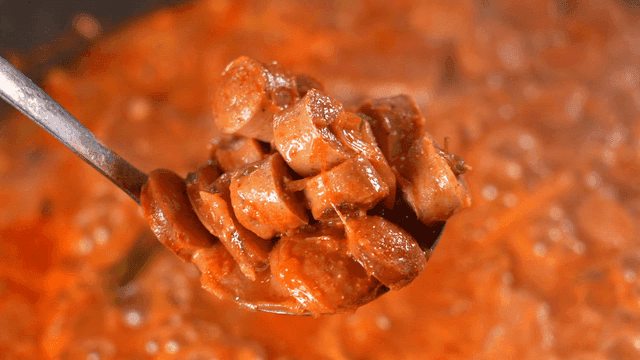 끓고 있는 부대찌개 소세지를 가득 퍼내는 국자