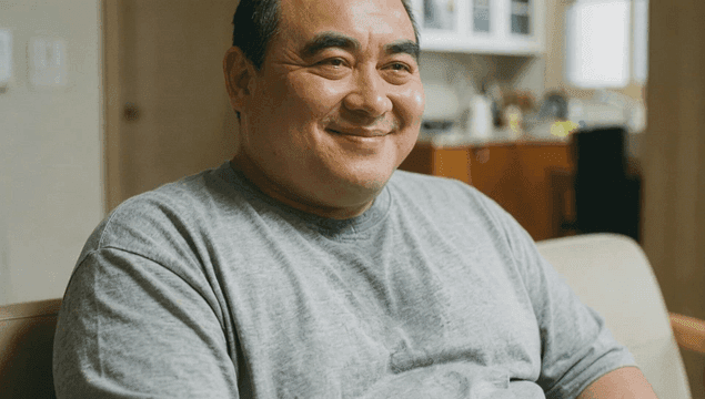 Fat middle-aged man sitting comfortably on sofa