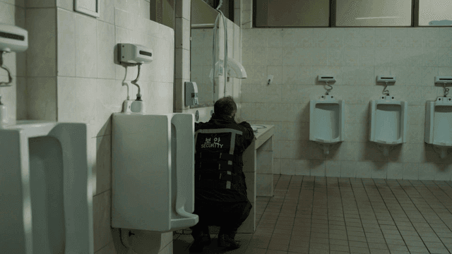 Man sitting on floor in bathroom talking on phone