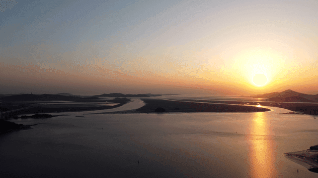 Sunset over calm sea and landscape