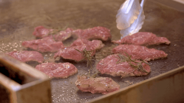 Grilling seasoned meat with rosemary