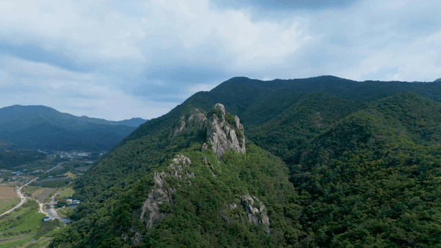 구름 낀 하늘 아래 푸른 산