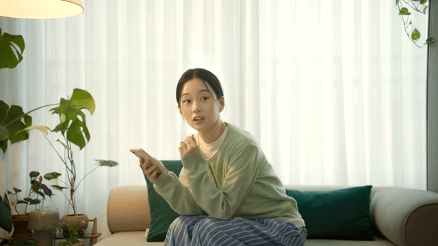 Woman sitting on sofa using her smartphone and running away