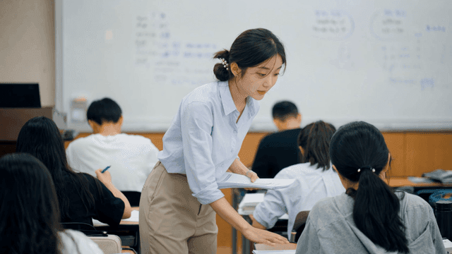 Teacher distributing documents in classroom