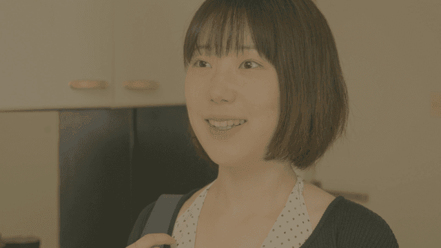 현관 앞에서 미소 지으며 인사하는 단발머리 여성