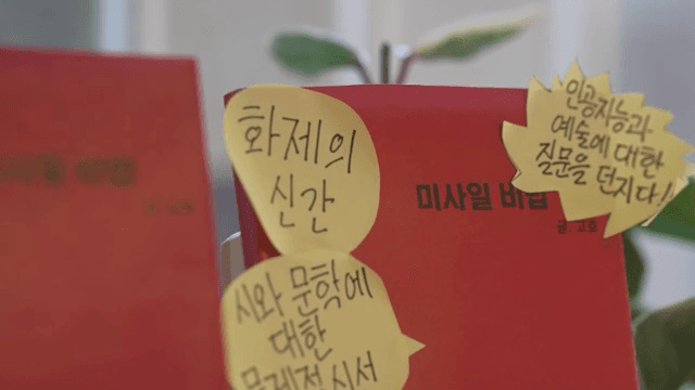 메모지가 붙어있는 책을 고르는 손