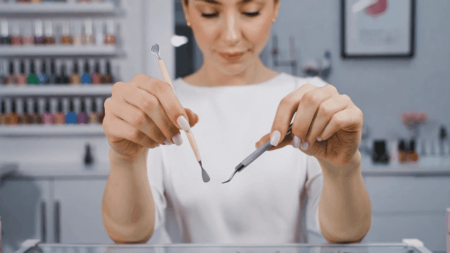 살롱에서 네일 아트 도구를 들고 있는 여성