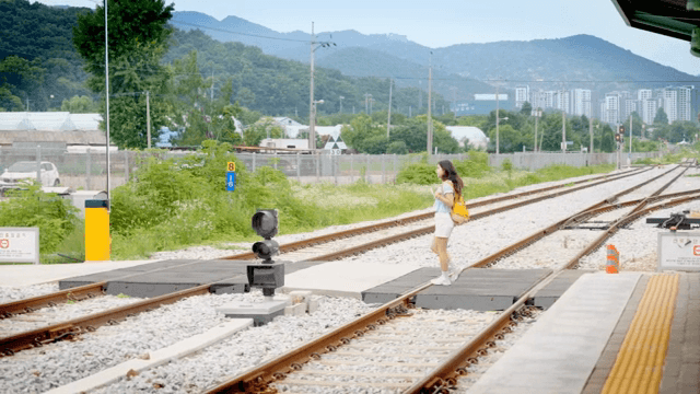 기차 플랫폼을 걷는 젊은 여성