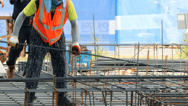 Construction workers handling rebar at site