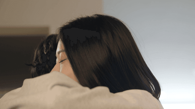 Couple hugging joyfully with wedding bouquet